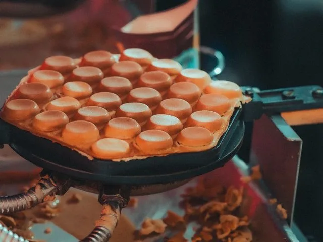 Ostyasütő gép (vafelni) működés közben, vékony ostyalapok sütése